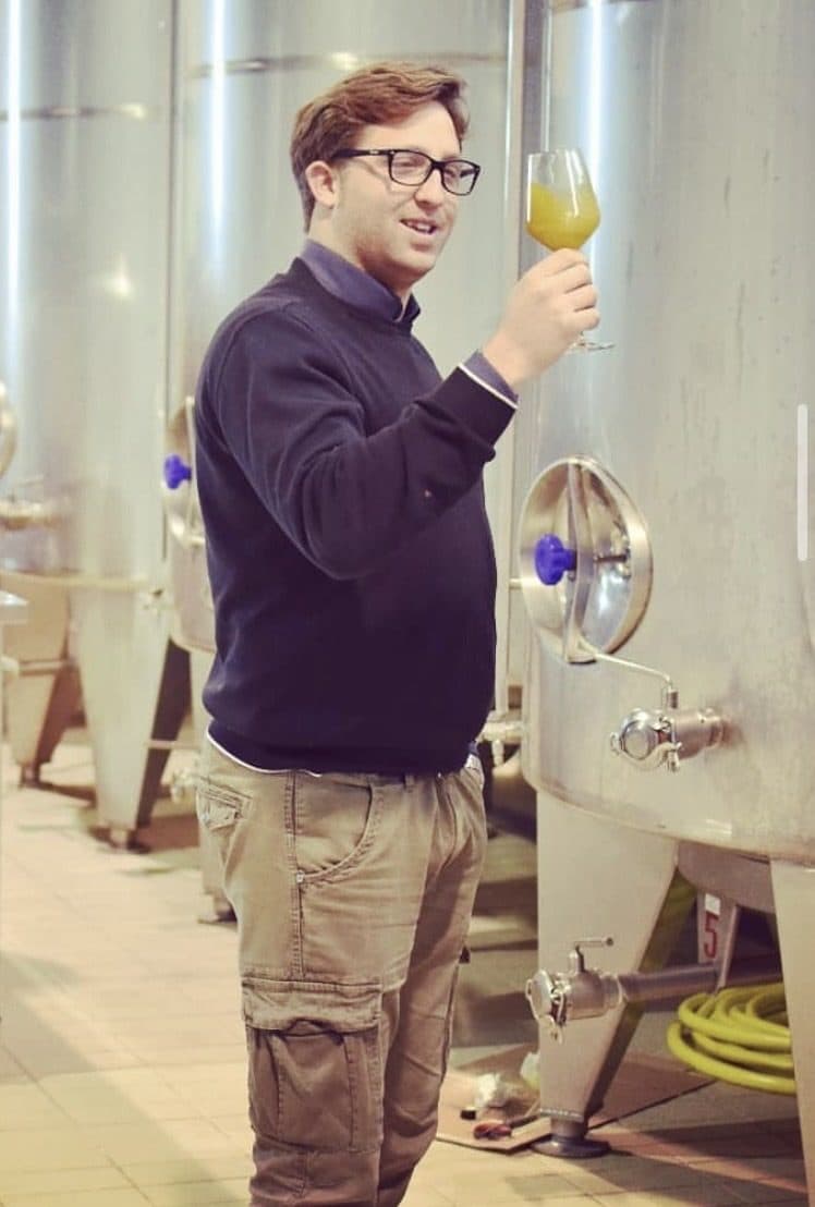 Assaggio dell'olio extravergine appena prodotto, tra i silos in acciaio di Tenute Carlo